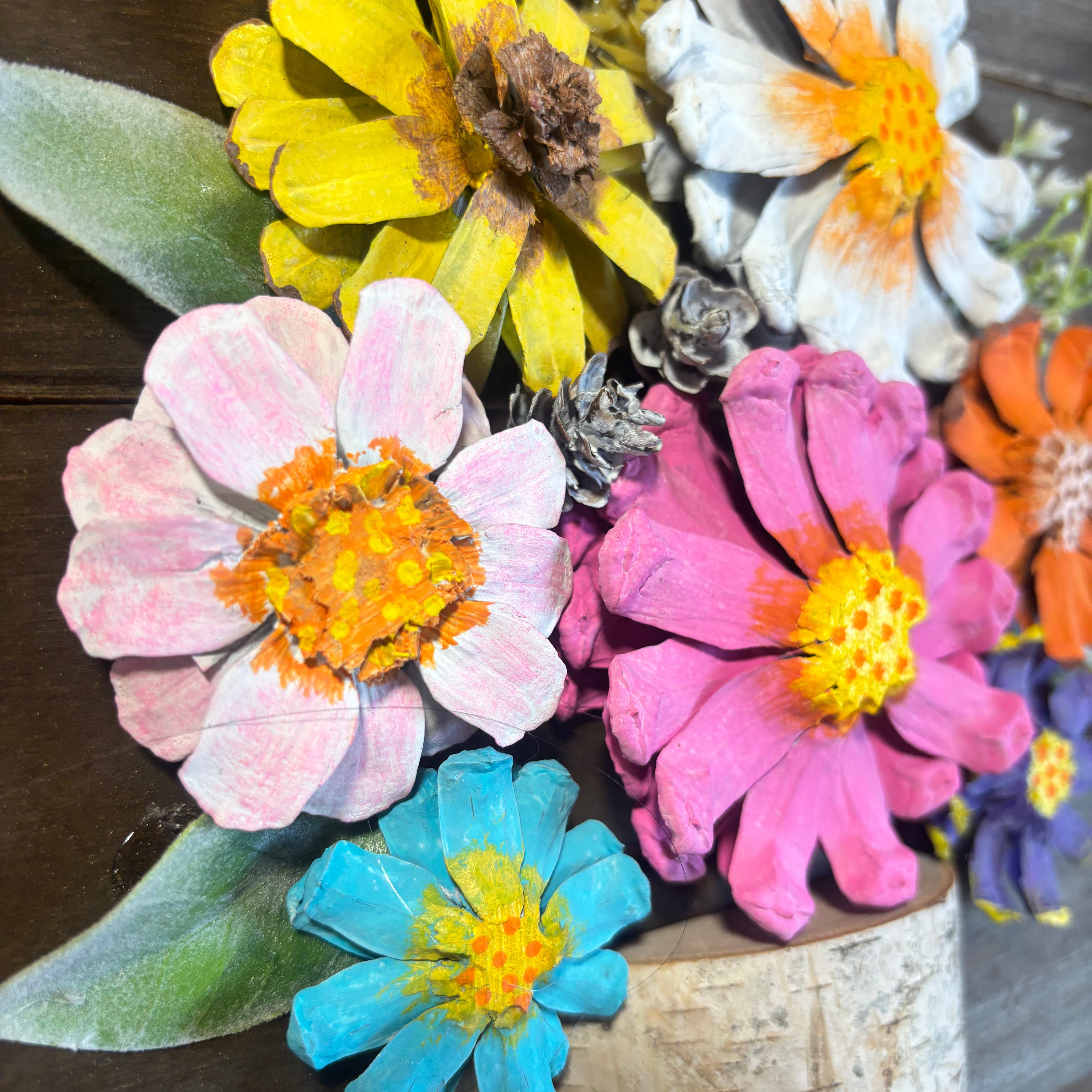 Colorful artificial flowers on a wooden surface