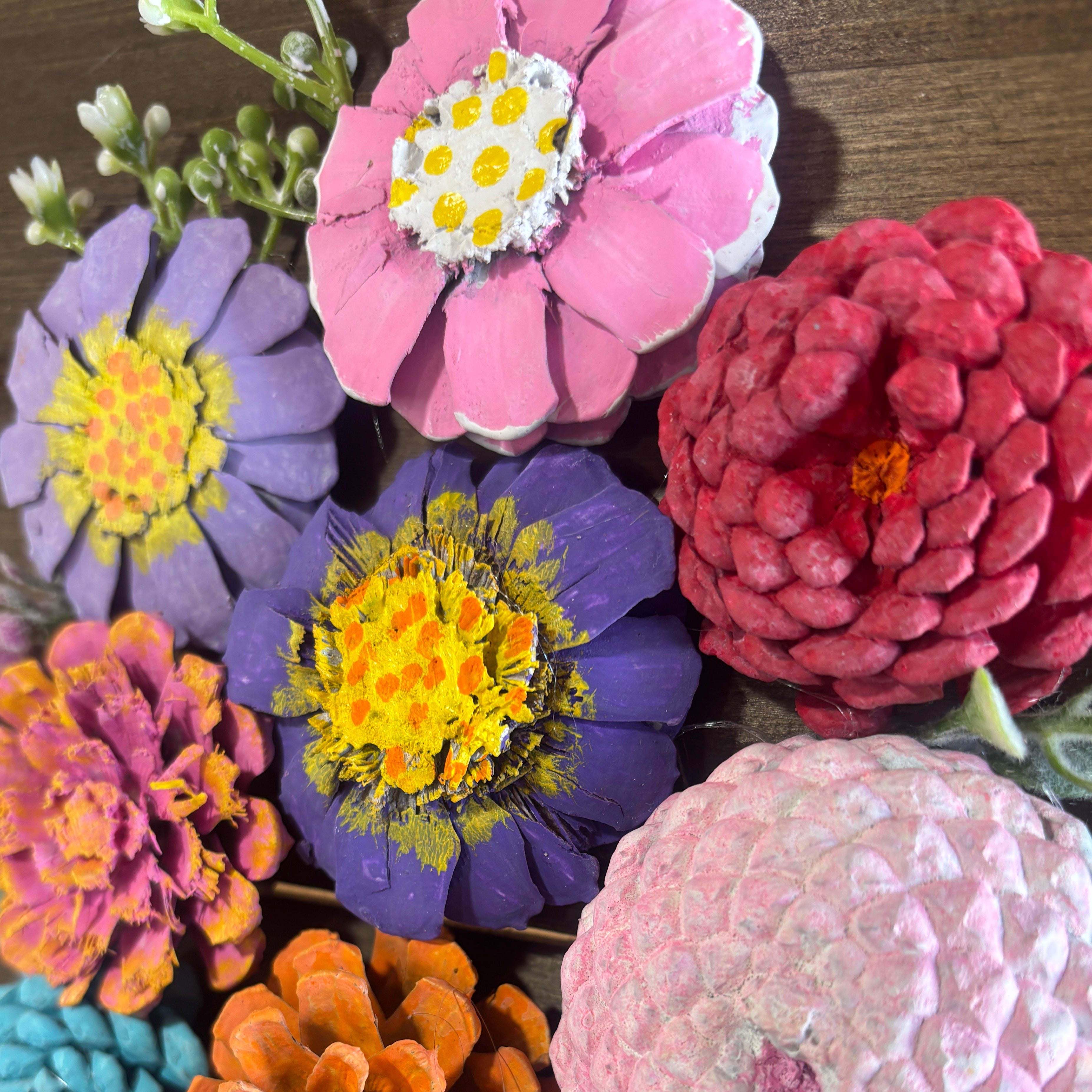 Colorful artificial flowers arranged on a wooden surface