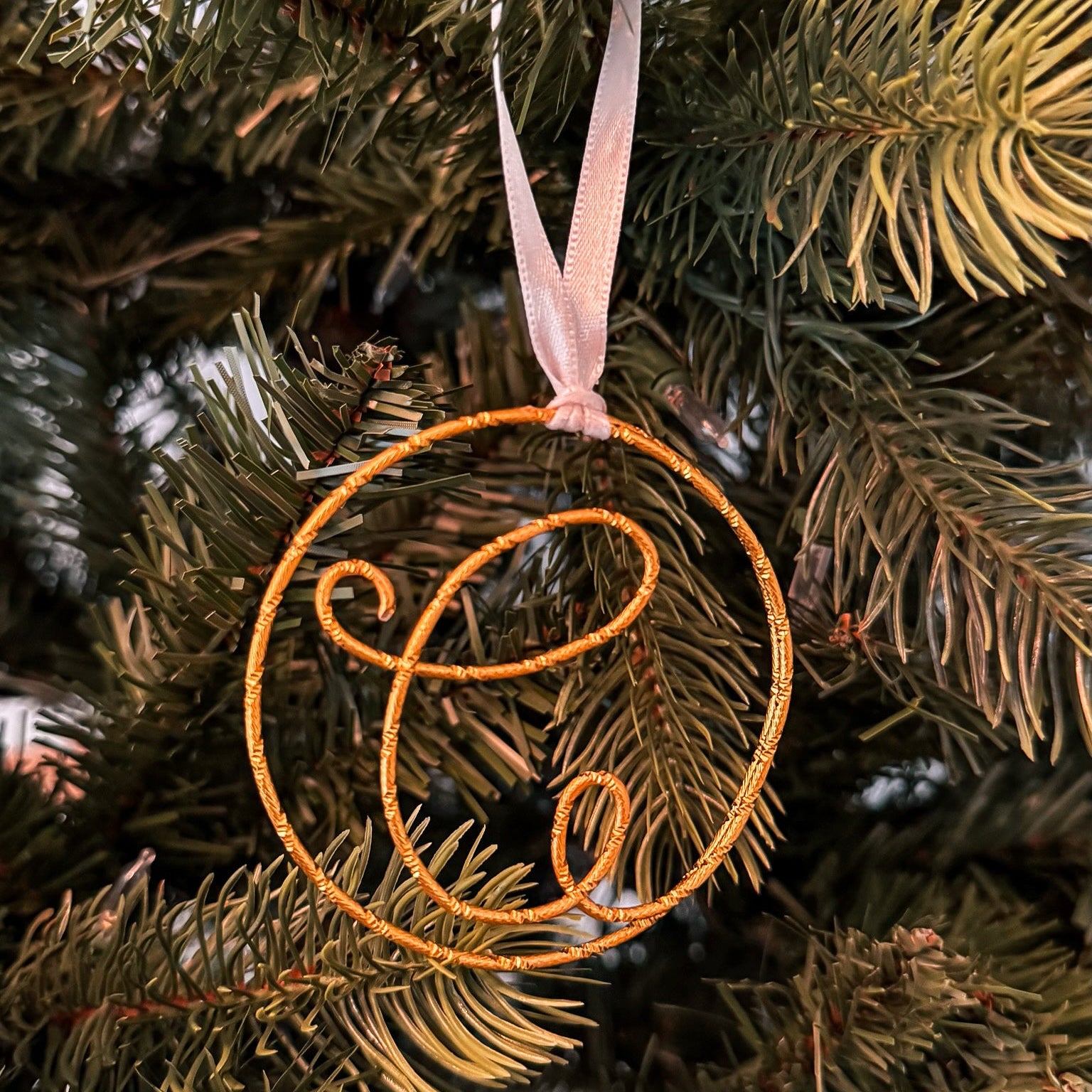 Decorative ornament with a monogram on a Christmas tree