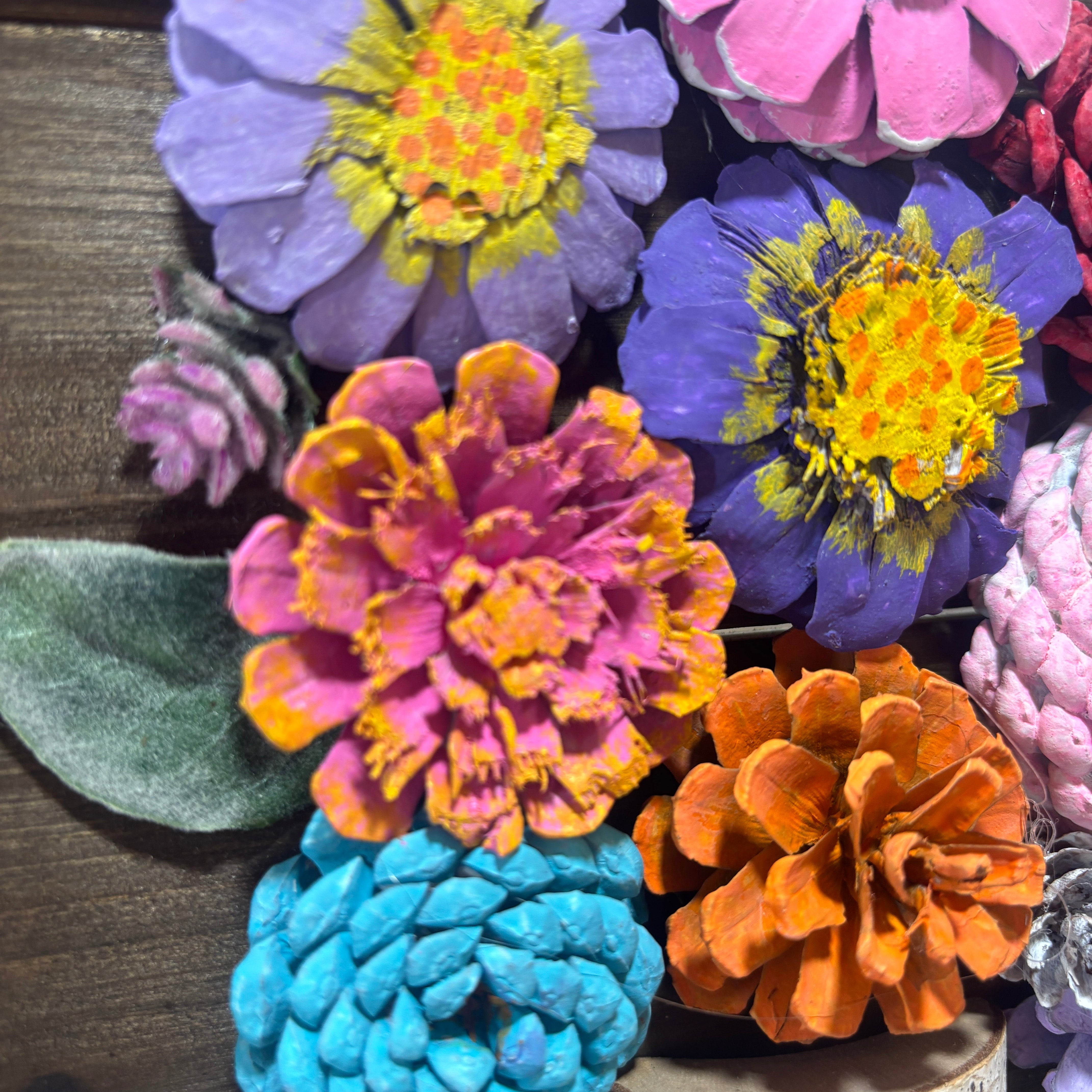 Colorful artificial flowers arranged on a wooden surface