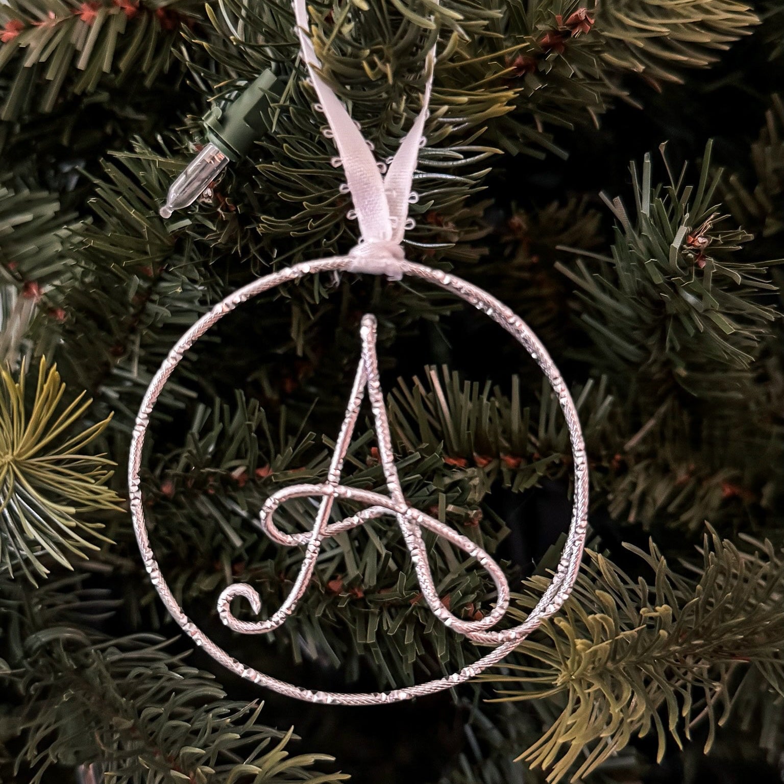 Decorative ornament with a letter 'A' on a Christmas tree.